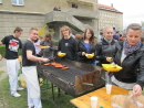 Na zdjęciu znajduje się grupa młodzieży przy grillu.