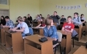 <p>Na zdjeciu znajduje się dzieci siedzące przy jednoosobowych stolikach.</p>