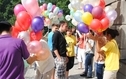 <p>Na zdjęciu znajduje sie grupa ludzi z kolorowymi balonikami.</p>