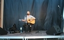 <p>Mężczyzna na scenie gra na gitarze i śpiewa</p>